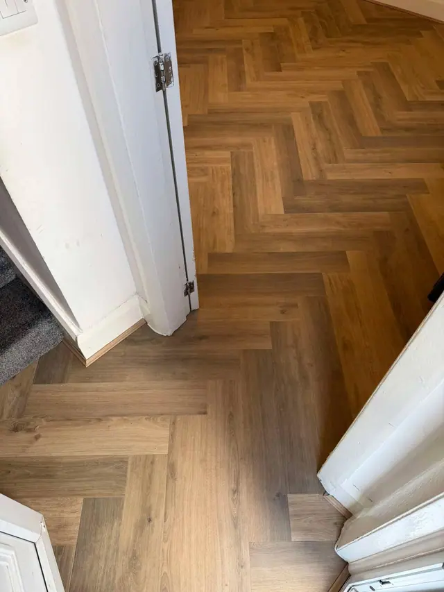 Warm herringbone laminate through a doorway