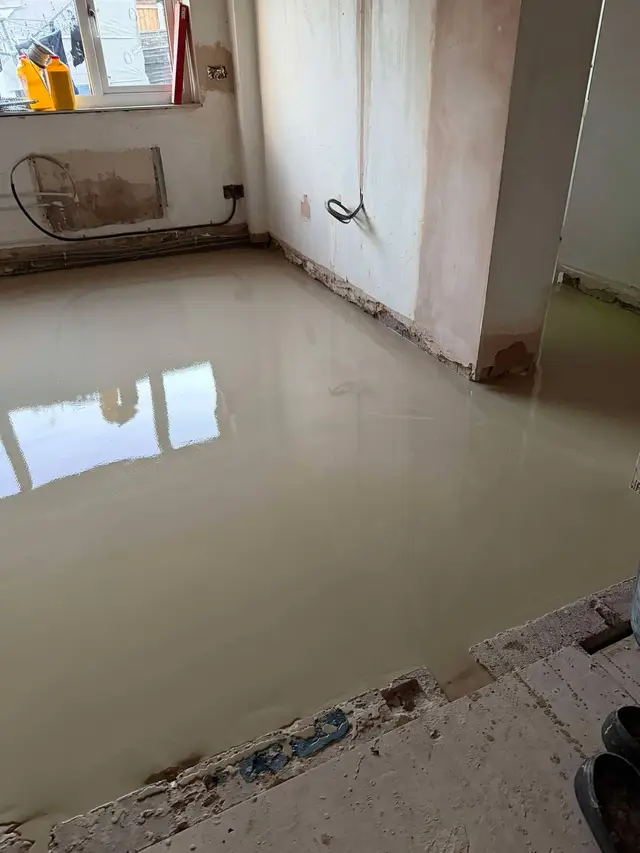Fresh smoothing compound across a kitchen subfloor