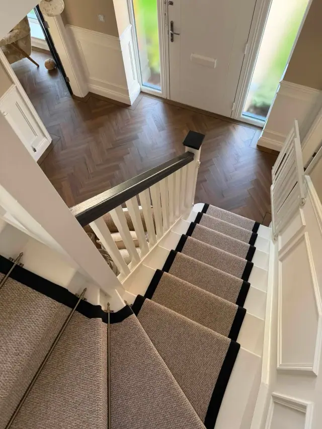A stair runner meeting a herringbone hallway